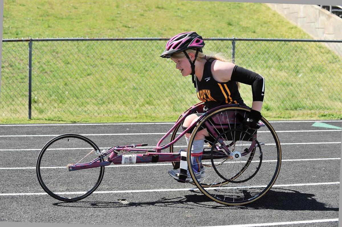 Apex’s Cara King wheels her way to the finish in the girls 200 meter adaptive race. High School track teams converged upon Garner High School for the Wake County Track Championships in Garner, N.C. on April 11, 2015.