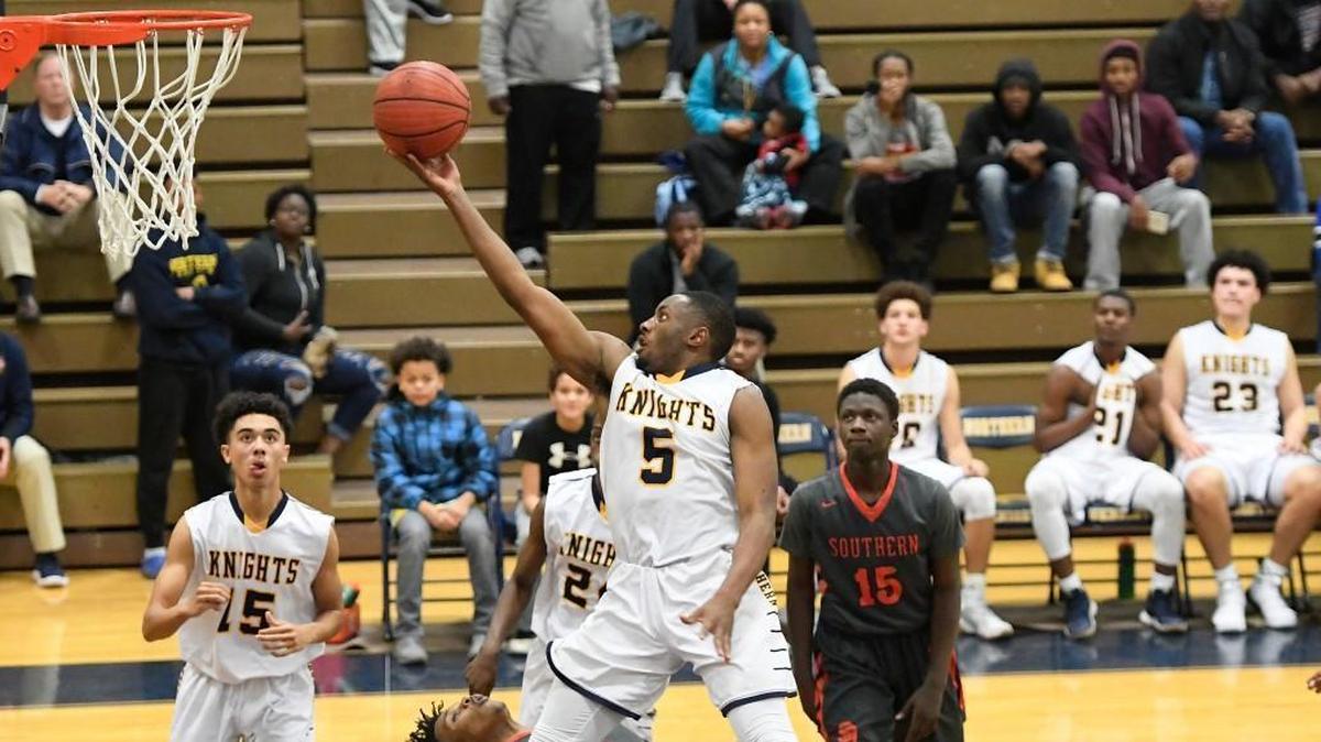 Jalen Johnson (5) of Northern Durham scores with a layup against Jalen Person (1) and Lamar Lightbrown (15) of Southern Durham. The Southern Durham Spartans visited the Northern Durham Knights in high school boys and girls basketball games on Dec. 12, 2017.