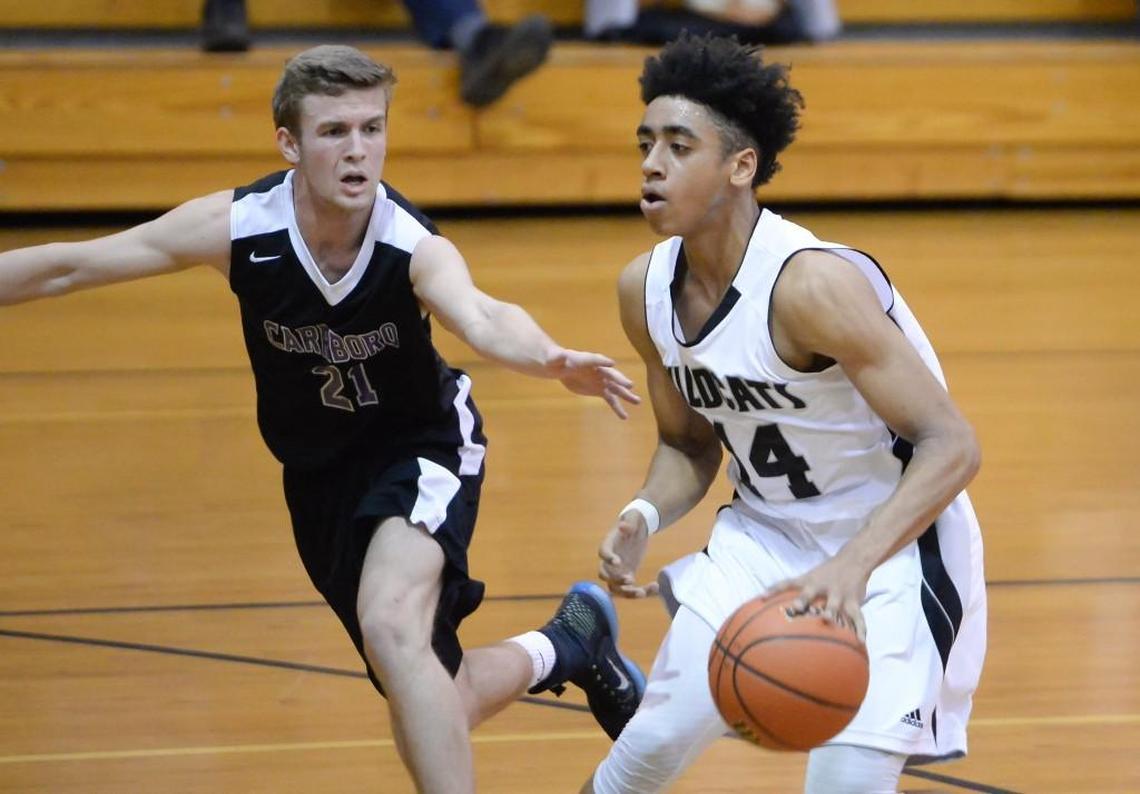Carter Collins (14) of East Chapel Hill dribbles the ball against Cole Phillips (21) of Carrboro. The East Chapel Hill Wildcats played the Carrboro Jaguars in a men basketball game that took place in Chapel Hill, N.C. on Friday, December 16, 2016. East Chapel Hill won 66-34.