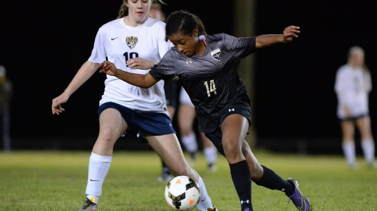 Shadae Nicholas (14) of Holly Springs dribbles past Alyssa Stone, right, of Northern. The Northern Knights played the Holly Springs Golden Eagles in a girls soccer game that took place in Durham, N.C. on Wednesday, March 2, 2016. Holly Springs won 3-0.
