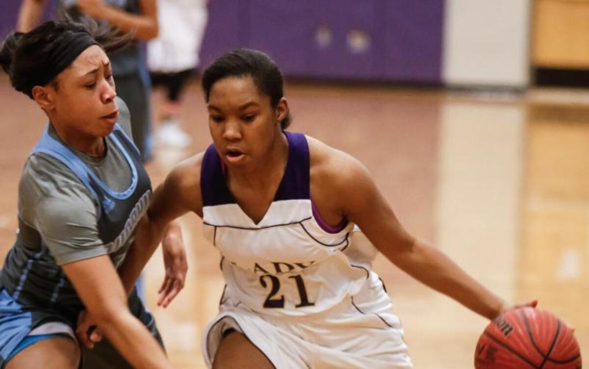 Holly Springs' Brianna Tate (21) drives past Overhills' Jaylen Smalls (10) during Overhills' girls basketball playoff game at Holly Springs on Tuesday, February 23, 2016. Holly Springs won the match 53-41.