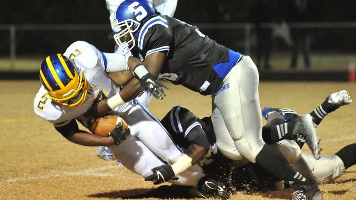 
East Wake's Damontay Rhem (2) is tackled by Scotland's Jon Carmichael (98) and Tyquan Ingram (44). East Wake took on Scotland in the second round of the NCHSAA 4A football playoffs in Laurinburg, N.C. on November 21, 2014. Scotland won 28-12.
