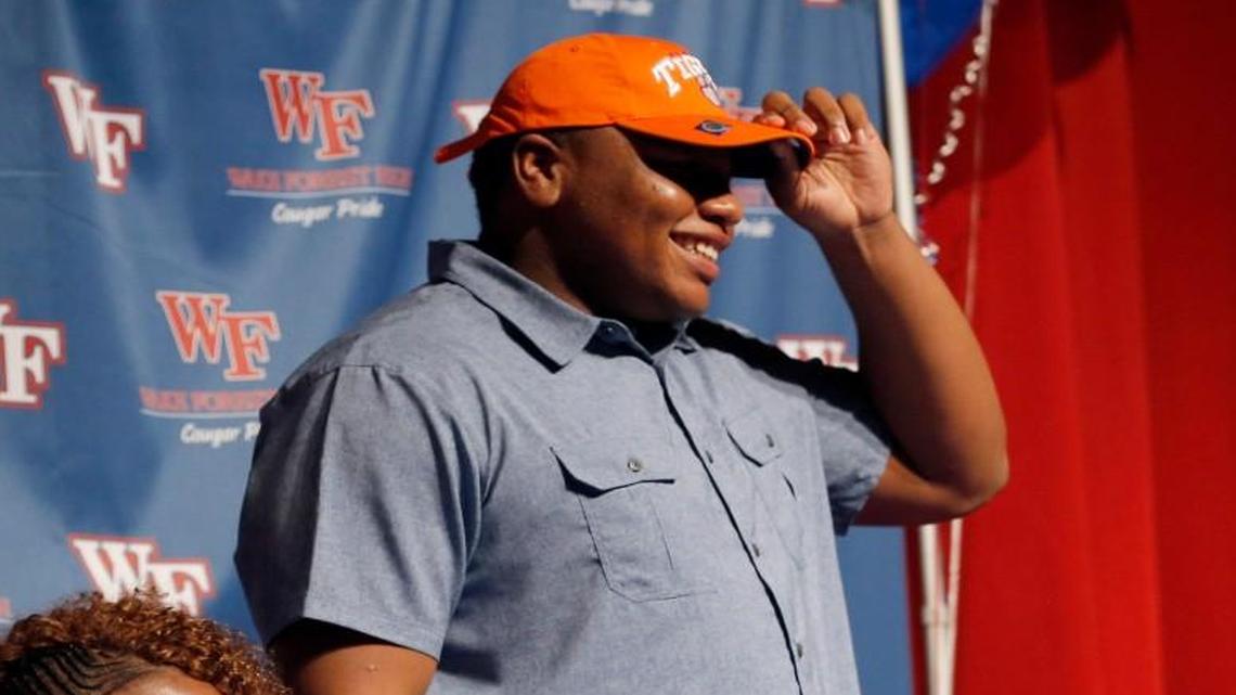 Julia Parker, left, cheers as her son, Wake Forest High School football standout Dexter Lawrence,announces he is headed to Clemson to play college football. Dexter Lawrence’s brother, fellow Wake Forest football player Devon Lawrence, is at right.