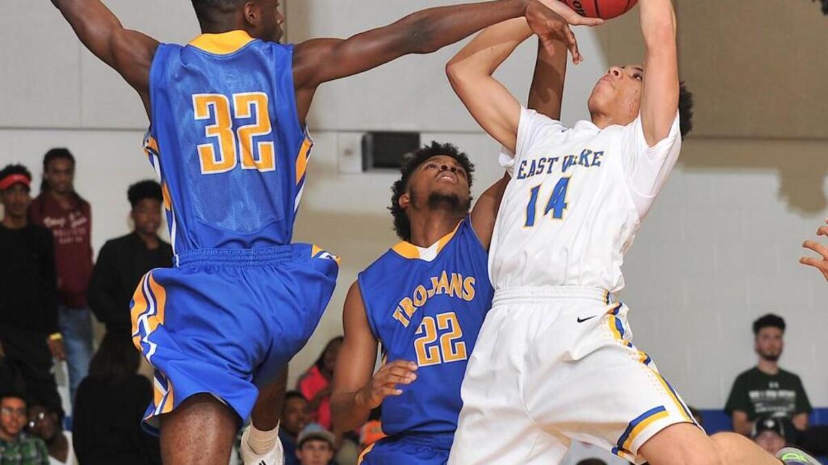 East Wake’s Jalen Vick (14) attempts the shot while defended by Garner's Omari Harris (32). The East Wake Warriors took on the Garner Trojans in basketball in Wendell, N.C. on December 11, 2015. Garner won 84-52.