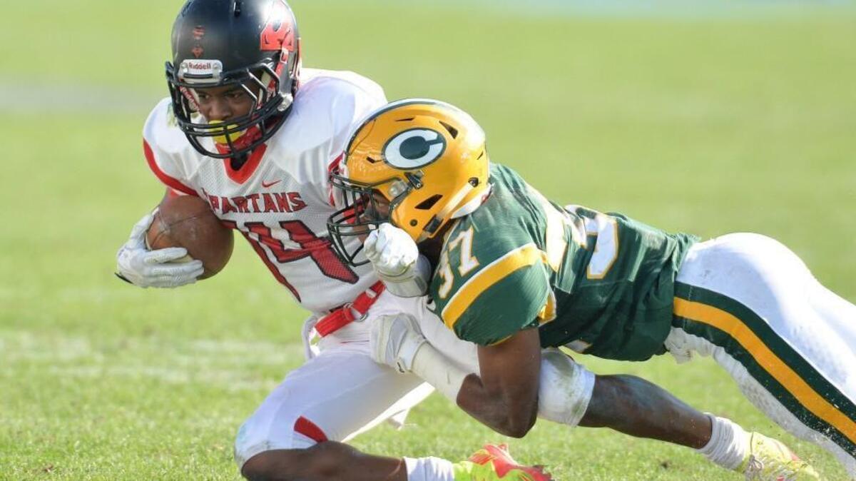 Jermaine Russell Jr. (14) of Southern is brought down by Jabbarri Foster (37) of Crest. The Southern Spartans played the Crest Chargers at the UNC Kenan Memorial Stadium in Chapel Hill, N.C. on Saturday, December 12, 2015. Crest won 55-21.
