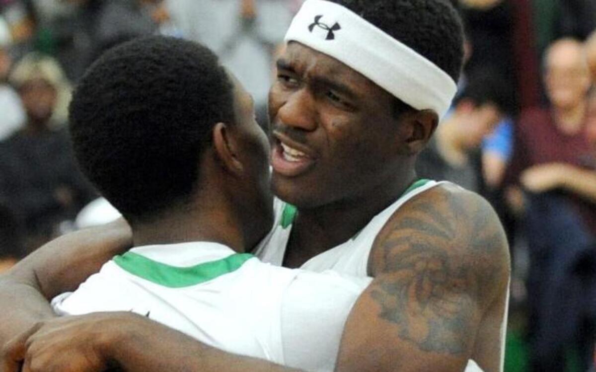 Cary's Donte Tatum and Darrion Burnett (11) celebrate their win over Leesville Road after the third round NCHSAA 4A playoff game, which was played in Cary on Saturday, February 27, 2016. Cary won 54-50.
