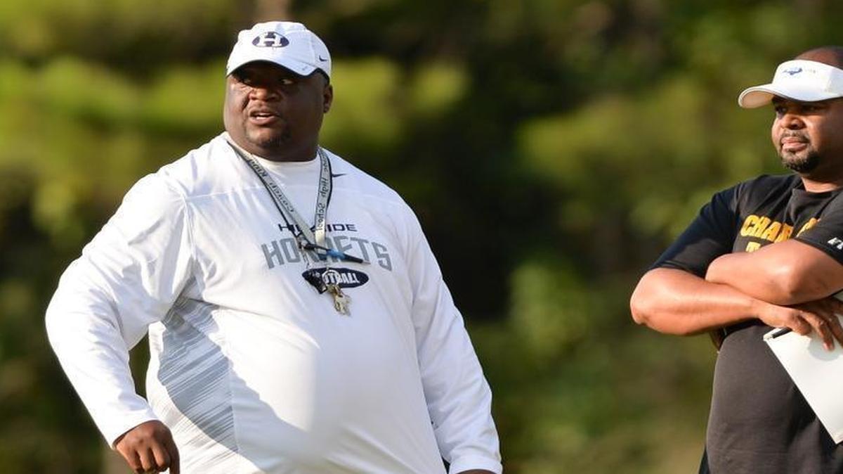 Hillside's head coach, Antonio King, left, and Chapel Hill's head coach, Isaac Marsh, right, talk before a preseason scrimmage on Thursday, August 13, 2015, in Chapel Hill.