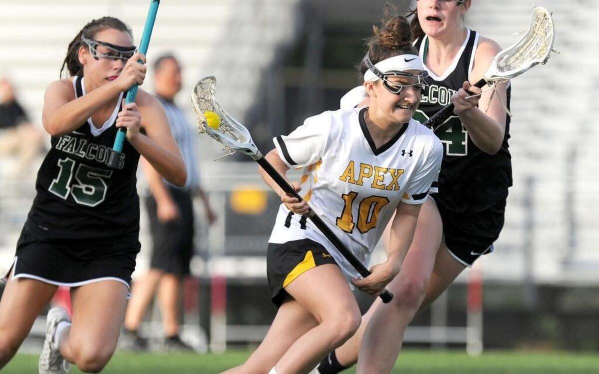 Apex's Emily Beckman (10) gets past Green Hope's Maddie McKinley, left, and Emily Schoeffler, right, during Apex’s 21-9 victory Friday, April 29, 2016.