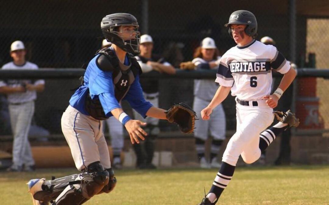 Heritage's Trent Harris (6) beats the throw to home plate as Wake Forest catcher Kyle Wilson (17) waits during Wake Forest's baseball game at Heritage on Tuesday, March 21, 2017. Heritage won the game 9-4.
