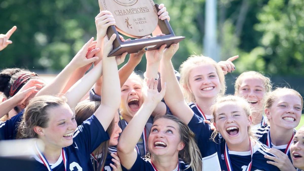 The Cary Christian team holds up the championship trophy following the NCISAA 2A girls soccer state championship match between Cary Christian and Asheville Christian at Campbell University on Saturday, May 20, 2017. Cary Christian won the game 3-0.