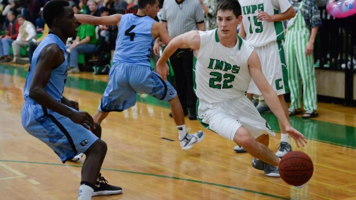 Cory Gensler (22) of Cary dribbles the ball against Justin Smalls, left, of Panther Creek. The Cary Imps played the Panther Creek Catamounts in Cary, N.C. on Tuesday, December 1, 2015. Cary won 67-45.