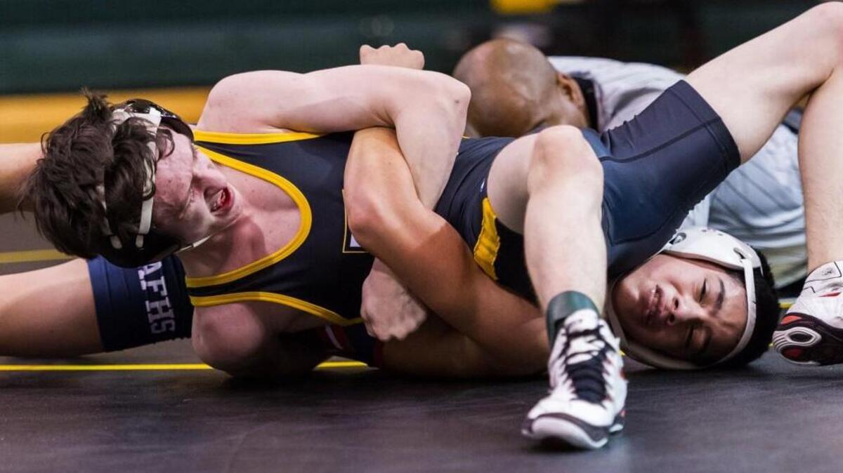 Apex Friendship's Gabe Baragona wrestles Apex High's Alec Montoya as the Apex Friendship Patriots took on the Apex High School Cougars at Apex high School in Apex, NC on Tuesday, December 8.