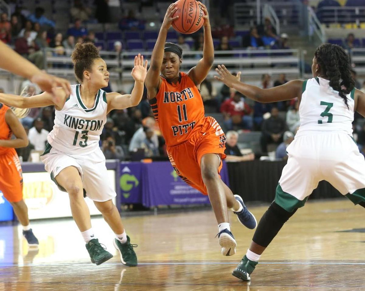 North Pitt's Nyjanique Langley (11) splits Kinston's Alena Rivers (13) and Sheriece Jones (3) on one her power drives down the lane. The Kinston Vikings and the North Pitt Panthers played in the girls 2A NCHSAA Eastern Regional basketball finals at East Carolina University on Saturday, March 3, 2018.