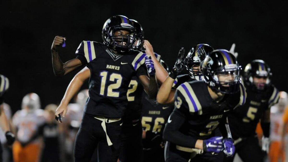 Holly Springs' Dekel Ballentine (12) celebrates a defensive stop against Fuquay-Varina in Holly Springs, N.C. on Friday, September 30, 2016. Holly Springs won 23-14.