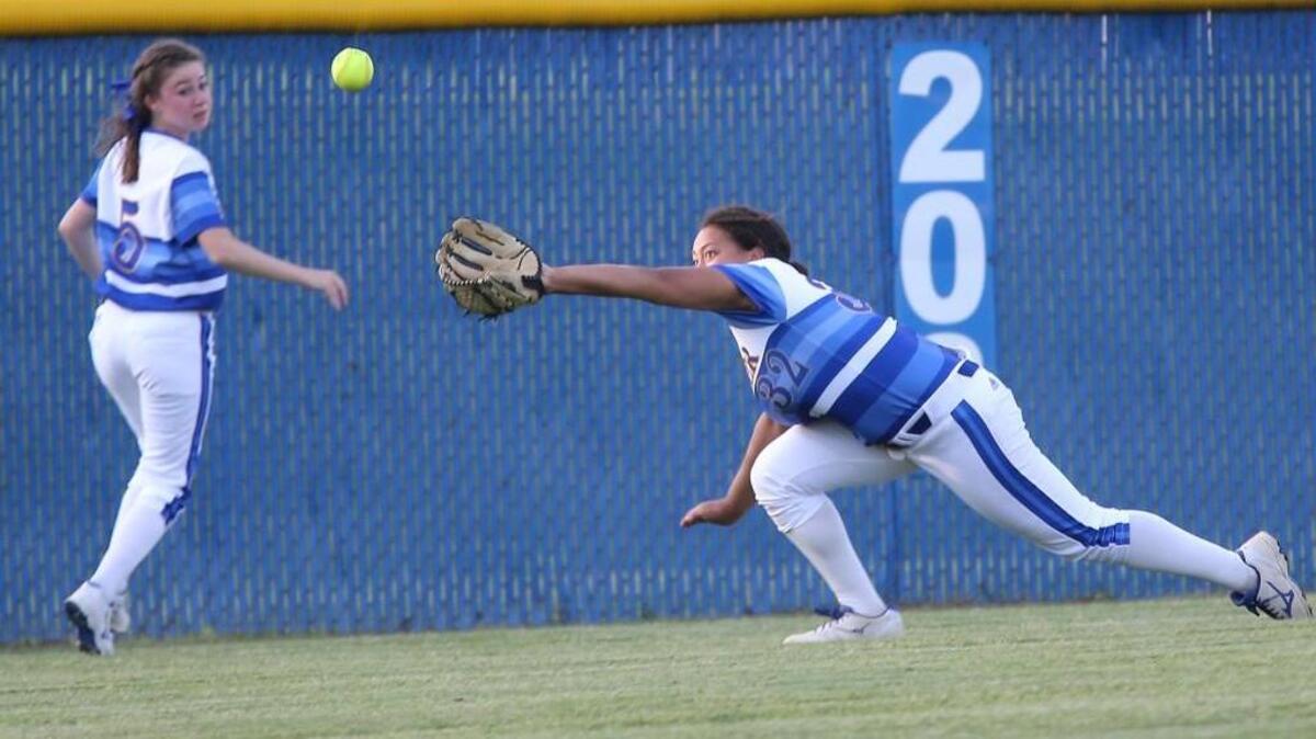 Garner's Alisha Josey (32) dives for the ball as Sydney Jones (5) looks on in the second round of the playoffs during the Hoggard High School softball game with the Garner Trojans High School on May 13th, 2016, in Garner, N..C . Hoggard won the game 3-1.
