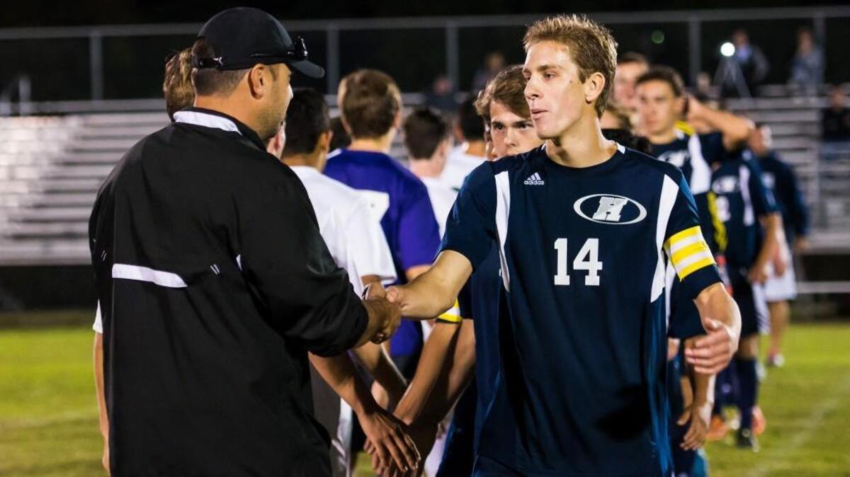 Heritage's Logan Shytle (14) shakes Enloe head coach Drew Womble’s hand after a soccer game on Wednesday, October 14, 2015 in Raleigh, N.C. Enloe and Heritage tied 5-5