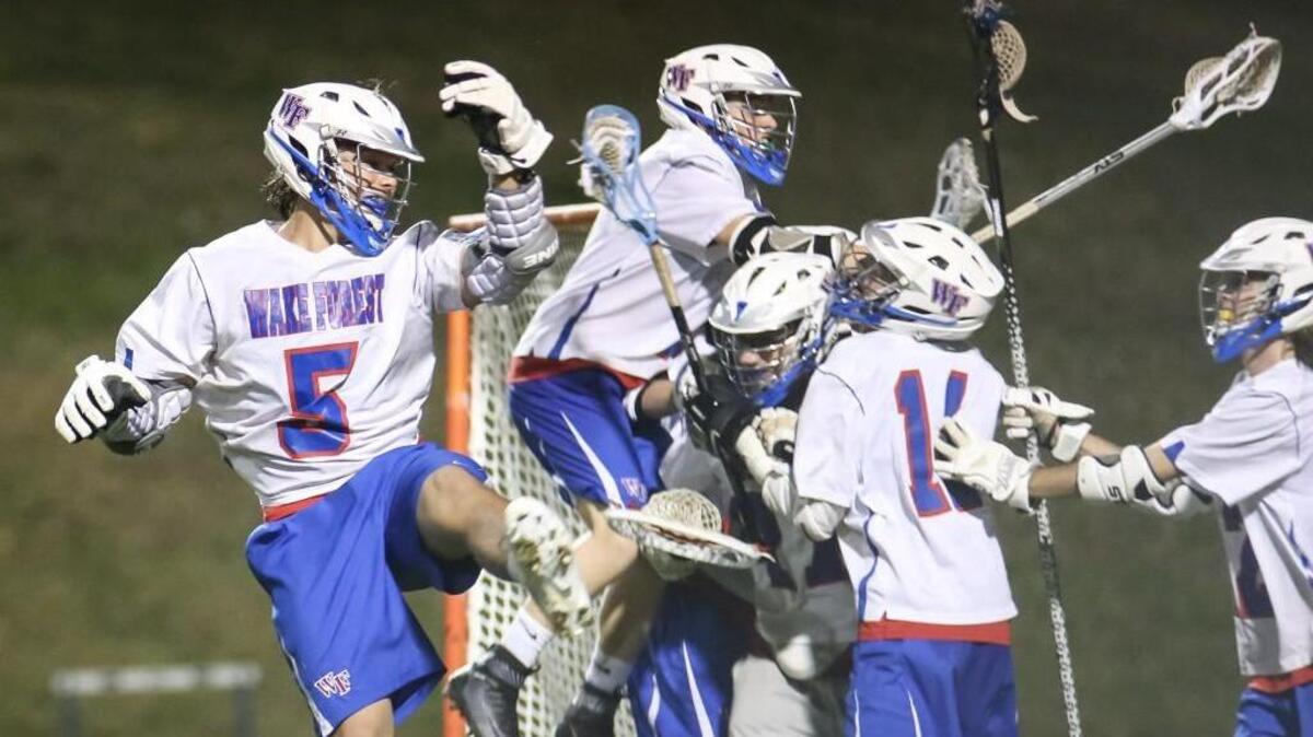 Wake Forest's Lance Bradley (5) joins the celebration with his teammates after the completion of Rolesville's boys lacrosse game at Wake Forest on Tuesday, March 28, 2017. Wake Forest won the game 12-8.