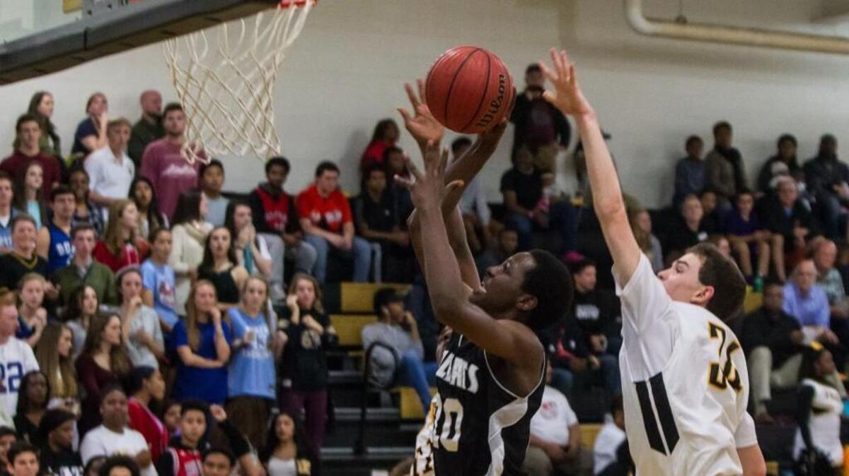 East Chapel Hill’s Jonathan Runyambo goes to the basket as Chapel Hill’s Max Conolly tries to swat it away.