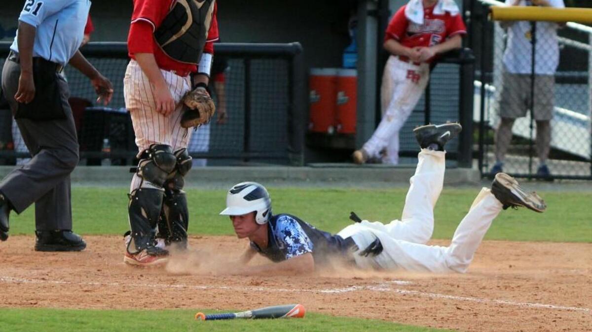 South Granville's Tucker Britt slides safely into home during game three of the 2A state baseball championship between South Granville and East Rutherford at Burlington Athletic Stadium in Burlington, N.C. on June 5, 2016.