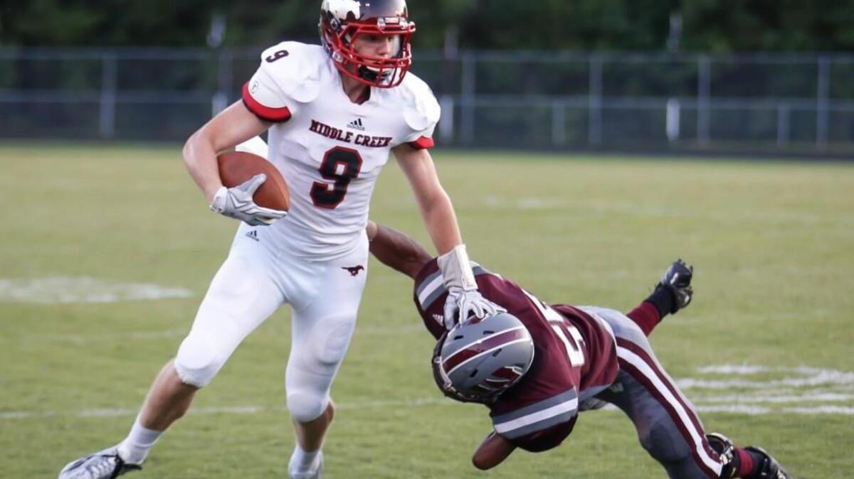 
Middle Creek’s Riley Frederikson (9) stiff-arms Wakefield defender Shelton Justice (55) during Middle Creek's football game at Wakefield on Friday, August 21, 2015.
