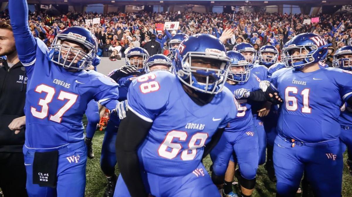 Wake Forest players Connor Sill (37), Dashawn Green (68) and Joshua Kruger (61) begin to celebrate and run onto the field as time expires in the NCHSAA 4AA football championship game between Greensboro Page and Wake Forest in Raleigh on Saturday, December 17, 2016. Wake Forest won the game 29-0.