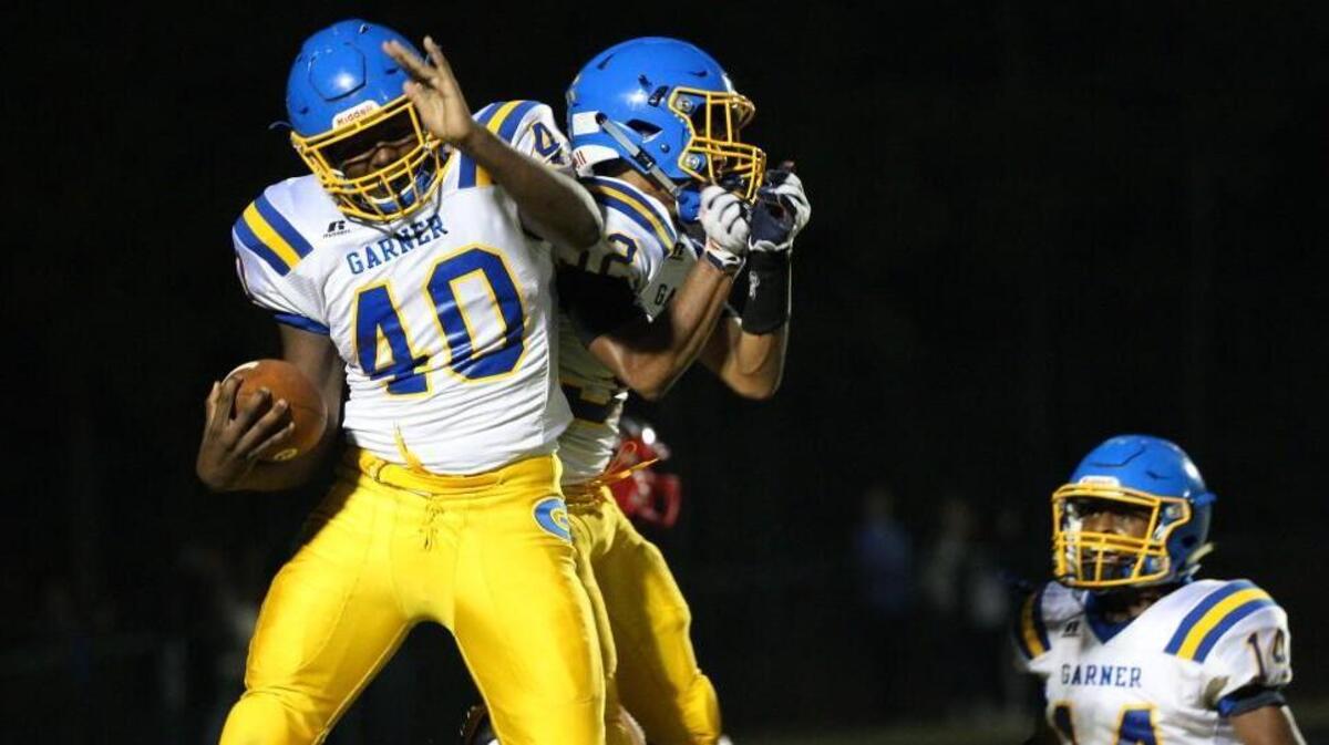 Garner's Spencer Stephenson (40) celebrates with Garner's Jon-Anthony Johnson (32) in the end zone . The Garner Trojans visited the Middle Creek Mustangs in a high school football game on Nov. 3, 2017.