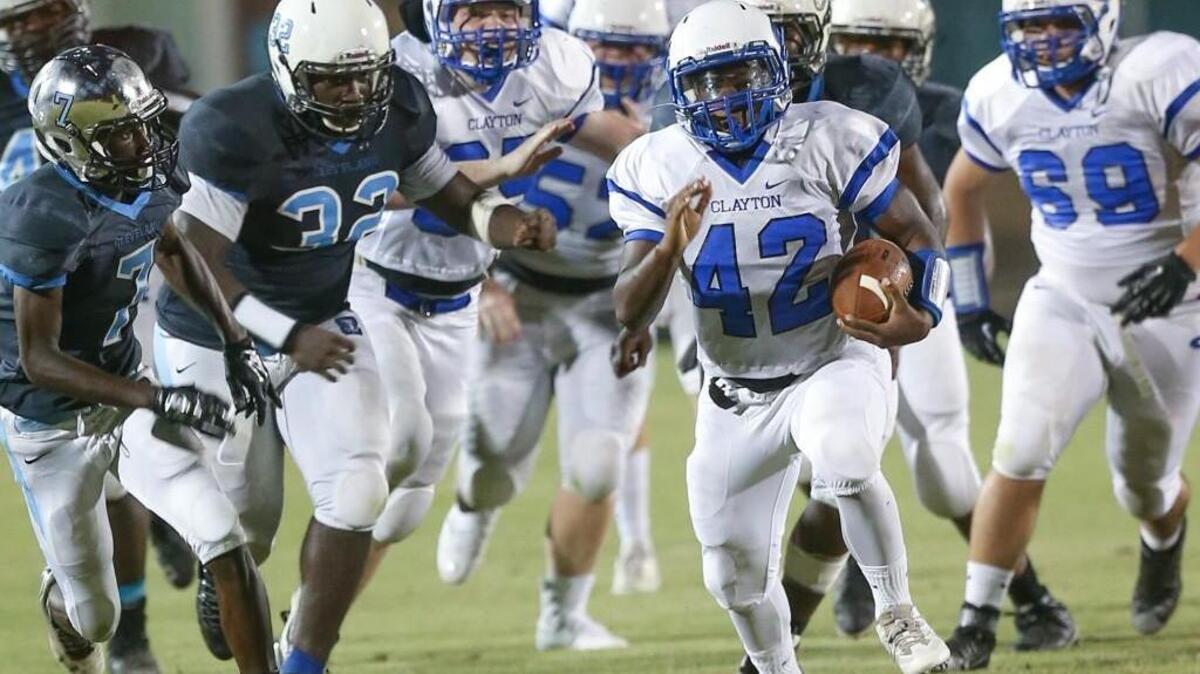 Clayton's Trevaun Richardson (42) breaks away from Cleveland's JaNathan Coward (32) for a big gain up the middle late in the 2nd quarter on Friday, August 19, 2016.