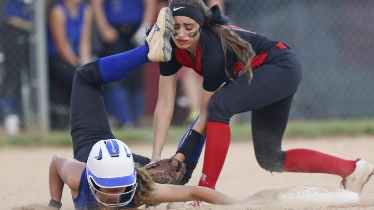 North Johnston’s Olivia Narron (0) takes a cleat to the head as she tags out Midway’s Brittany Watson (6) on a stolen base attempt during the first round of the NCHSAA 2A softball playoffs.