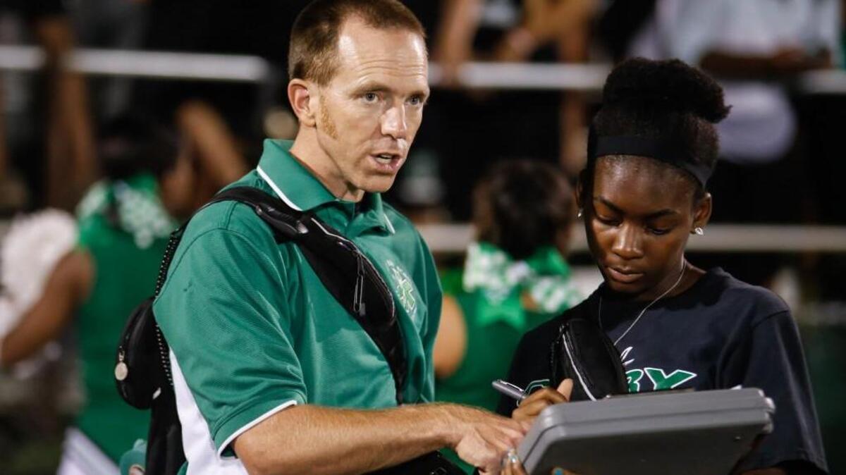 Cary athletic trainer Eric Hall talks with Cary senior Maula Herring as she fills out an injury report during Apex's football game at Cary on Friday, September 16, 2016. Apex won the game 35-34.