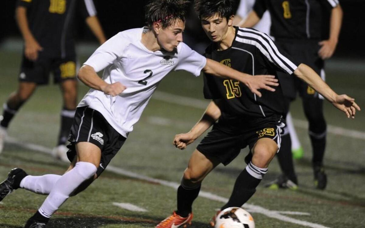 Cardinal Gibbons' Zachary Clements (2) drives past Enloe's Will Felt (15) in their 4A playoff game in Raleigh, N.C. on Thursday, November 12, 2015.