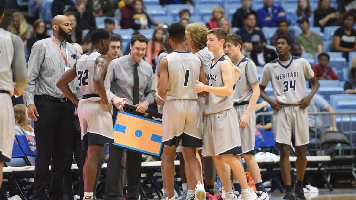 Tilden Brill, third from left, head coach of Heritage instructs his team during a timeout. The Heritage Huskies played the Independence Patriots in a boys basketball game that counted for the NCHSAA 4A championship that took place at the UNC Dean Smith Center in Chapel Hill, N.C. on Saturday, March 10, 2018. Independence won 71-60.