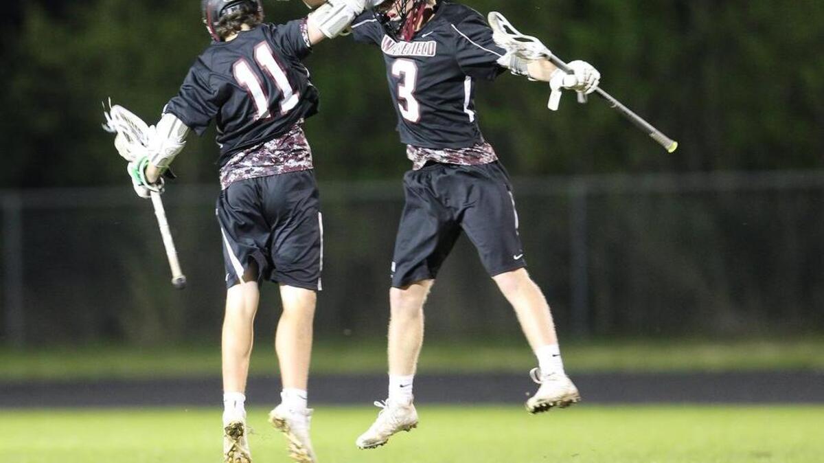 Wakefield's Kevin Ritter (11) celebrates with Connor Pirrung ( 3) during the Wakefield Wolverines high school lacrosse game with the Heritage Huskies high school on April 4, 2017. Heritage won the game 17-15.