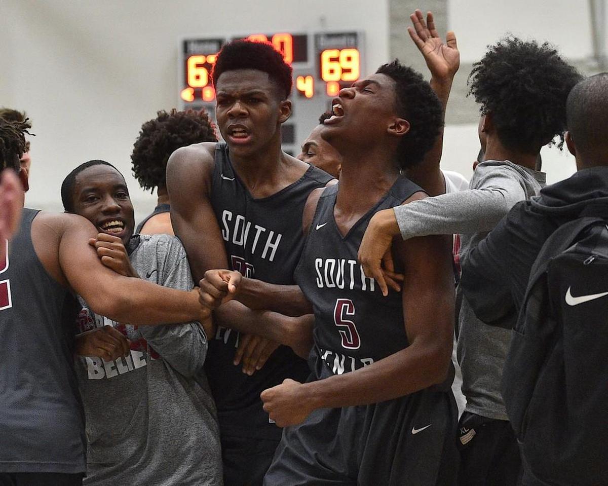 South Central's Cydney Williams (5) and Day'ron Sharpe (23) celebrate with teammates and fans after their victory over Garner in the NCHSAA 4A playoffs. The South Central Falcons took on the Garner Trojans in the fourth round of the NCHSAA4A boys basketball play offs in Garner, N.C. on February 27, 2018. South Central edges Garner 69-67.