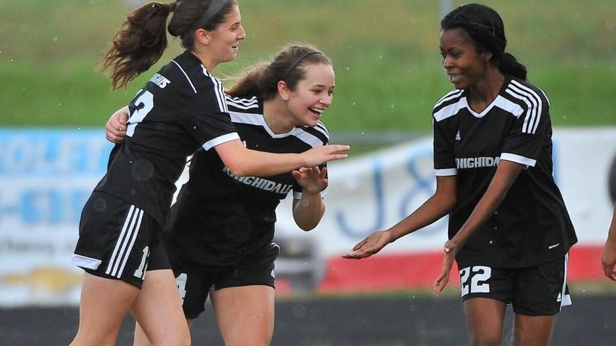 Knightdale’s Erin Giunco (12) and Leah McCray (22) celebrate with Gracie Gerald (14) after she scored a goal in May.