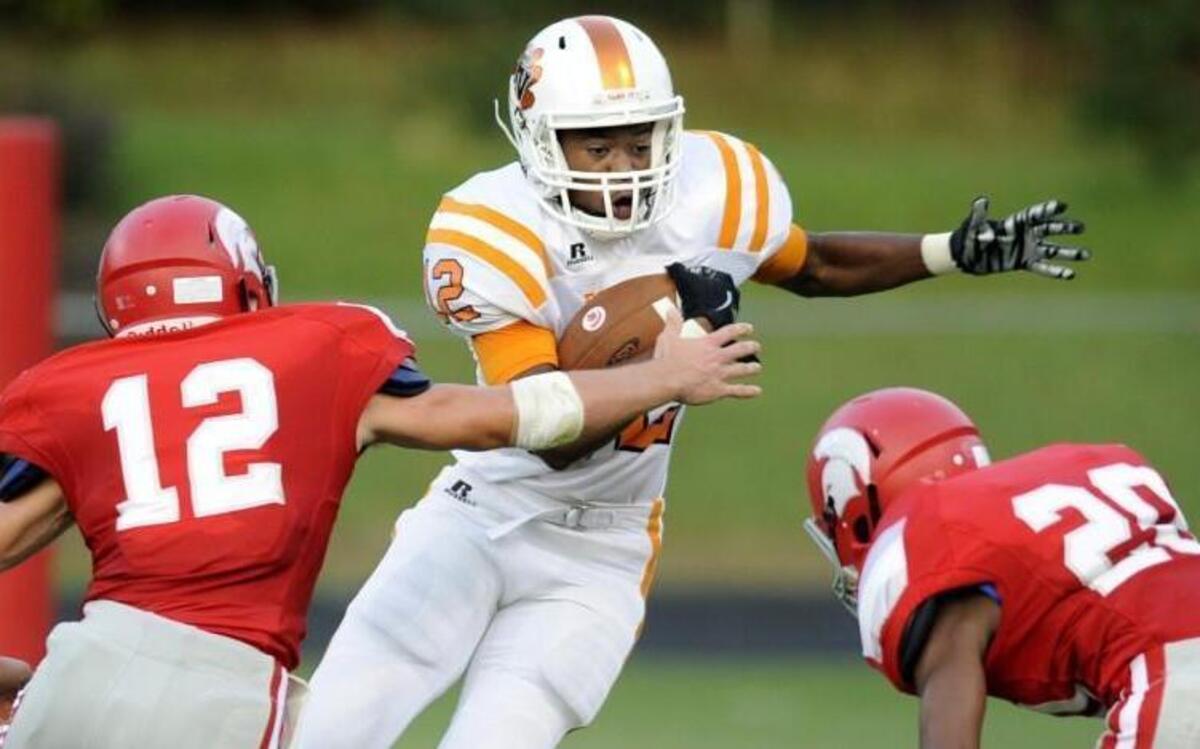 
Fuquay-Varina's Trey Thornton (12) tries to avoid Sanderson defenders Ryan Baldy (12) and Tae Jones (20).

