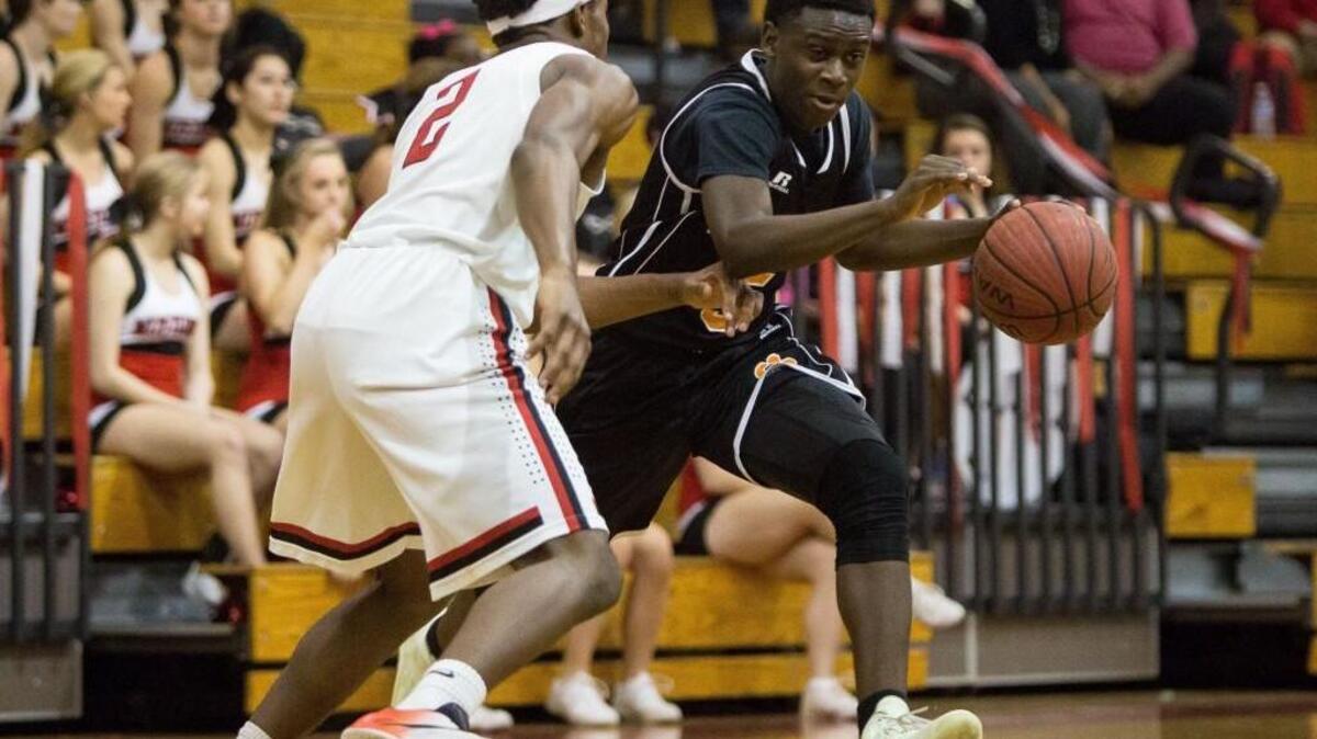 Fuquay Varina’s Ladji Samoura (5) handles the ball as Middle Creek’s Demetrius Bastian (2) defends during a high school basketball game in Apex, N.C. on Friday, Feb. 5, 2016.