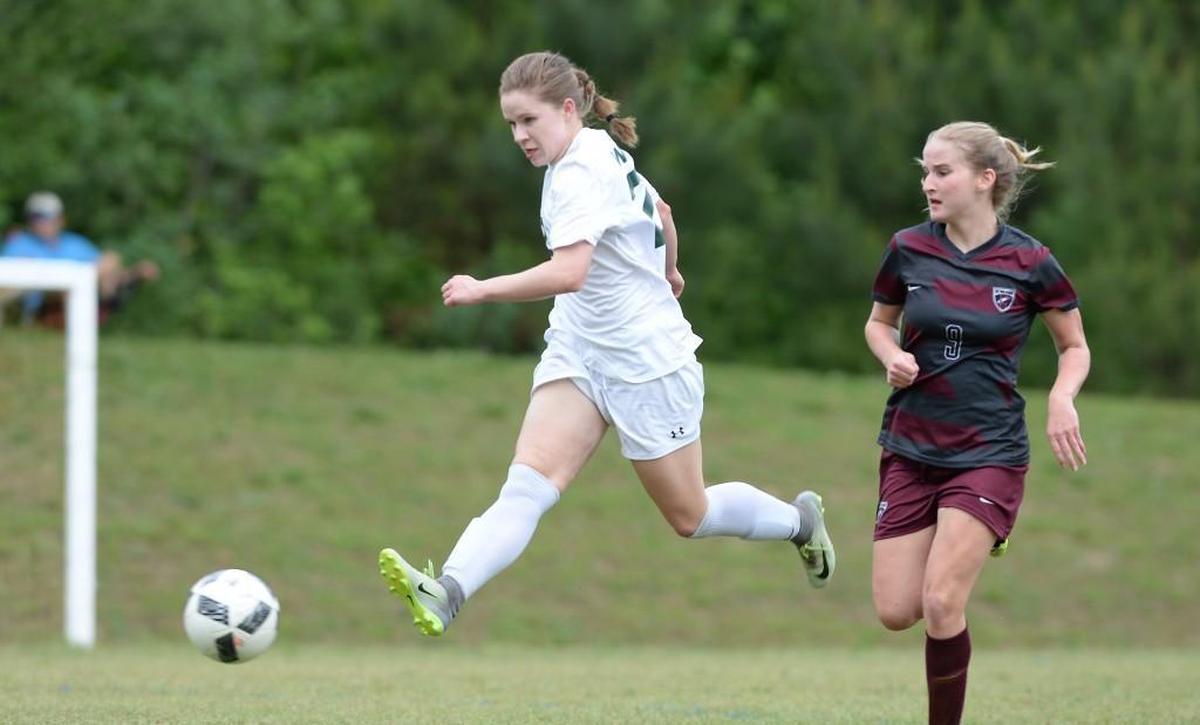 Isabel Pearce (22) of Woods Charter breaks through the marking of Haley Turner (9) of East Wake Academy to score the first goal for the Wolves. The Woods Charter Wolves played the East Wake Academy Eagles in a girls soccer game that took place in Chapel Hill, N.C. on Monday, May 1 2017. Woods Charter won 3-0.
