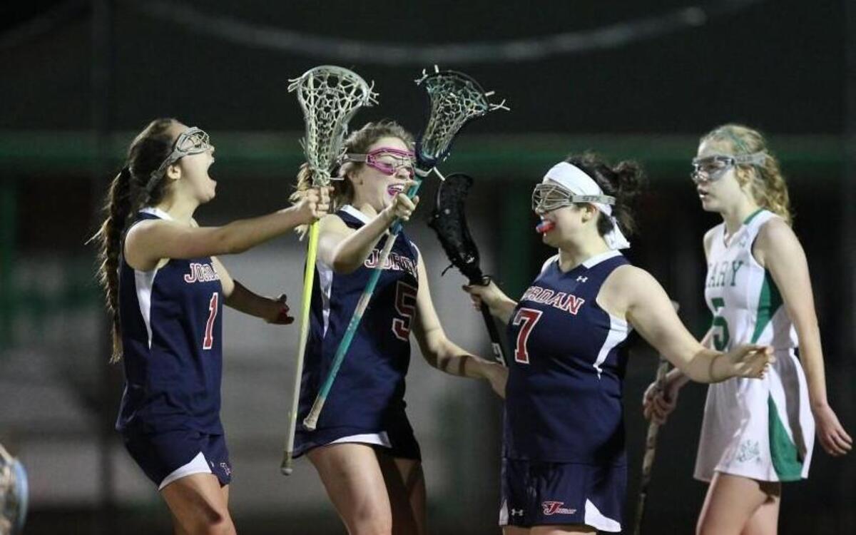 Jordan's Lindy Charles (7) celebrates the winning shot with Jordan's Kaylyn Posada (left) and Jordan's Riley Sipe (middle) during the Jordan Falcons high school lacrosse game with the Cary Imps high school, March 8, 2017, in Raleigh , N.C. Jordan won 11-10.