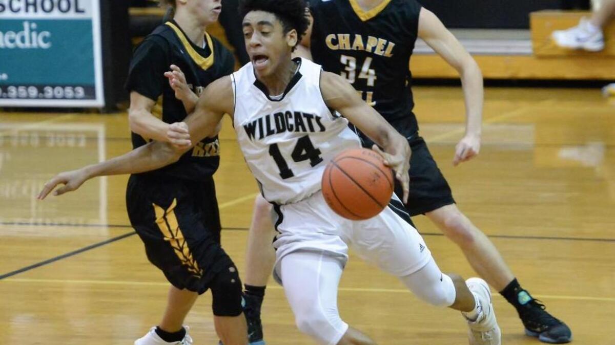 Carter Collins (14) of East Chapel Hill moves the ball against Elijah Haynes, left, and Maxwell Conolly (34) of Chapel Hill. The East Chapel Hill Wildcats played the Chapel Hill Tigers in a men basketball game that took place in Chapel Hill, N.C. on Friday, November 18, 2016. East Chapel Hill won 59-35.