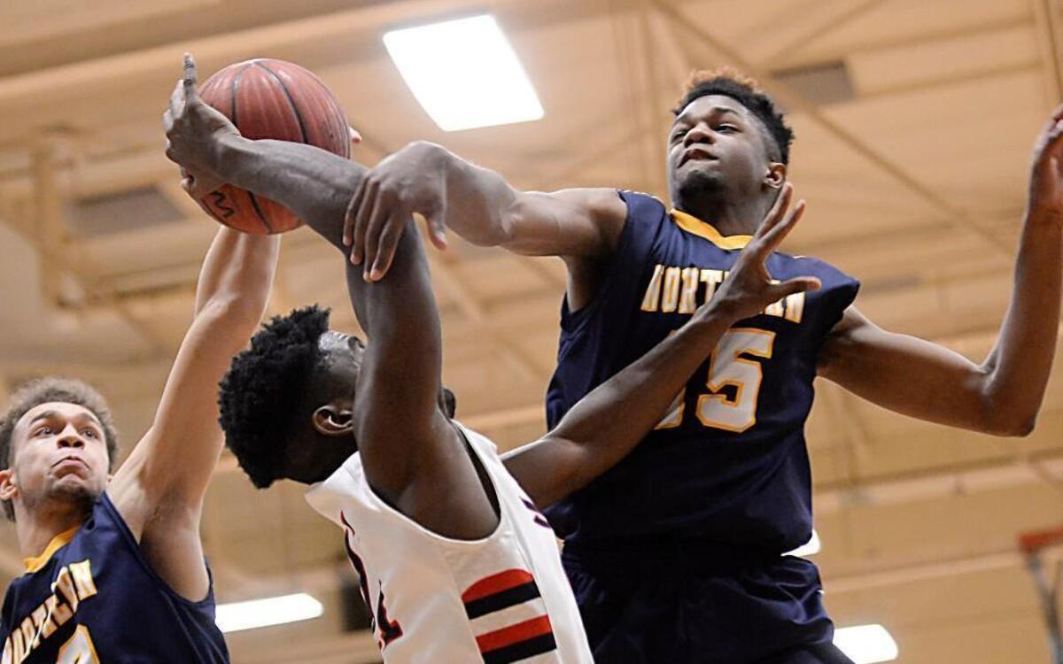 Preston Edwards, center, of Jordan gets his shot blocked by Emmett Tilley (12) and Timothy Bell (15) of Northern. The Jordan Falcons played the Northern Knights in a boys basketball game that took place in Durham, N.C. on Friday, January 29, 2016. Northern won 78-67.