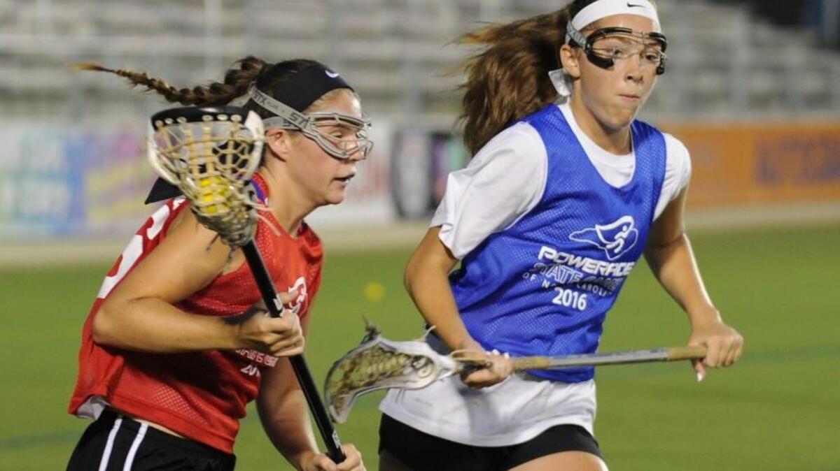 West's Carlee Seybert (left) is paced by East's Shannon Wulff during the Powerade State Games lacrosse match, which was played on Thursday, June 23, 2016 in Cary. West won 14-11.