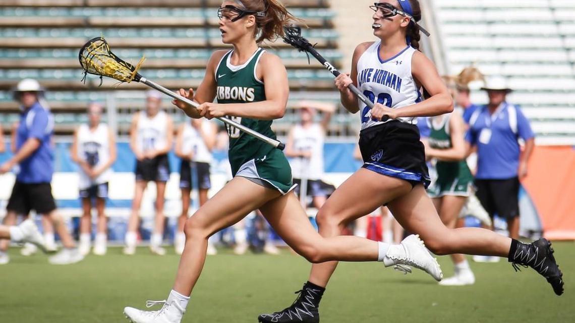 Cardinal Gibbons' Erica Skowron (19) runs with the ball as Lake Norman's Elena Dworschak (20) trails her during the NCHSAA State Championship girls lacrosse game between Lake Norman and Cardinal Gibbons at WakeMed Soccer Park on Saturday, May 21, 2016. Cardinal Gibbons won the game 18-14 and Skowron was named MVP.