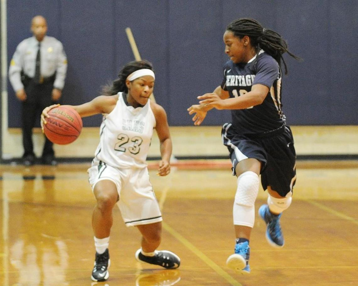 Southeast Raleigh's Makayla Sutton (23) drives up the court defended by Heritage's Melicia Mouzzon (10) in Raleigh on Nov. 26, 2016.