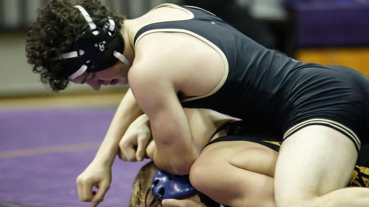 Holly Springs' Cam Devers, top, uses a half nelson to try turning Wilmington Laney's David Bostian onto his back, winning their 138-pound match 4-3 during the 4A East regional finals between Holly Springs and Wilmington Laney in Fayetteville on Thursday, February 4, 2016. Holly Springs won 26-25.