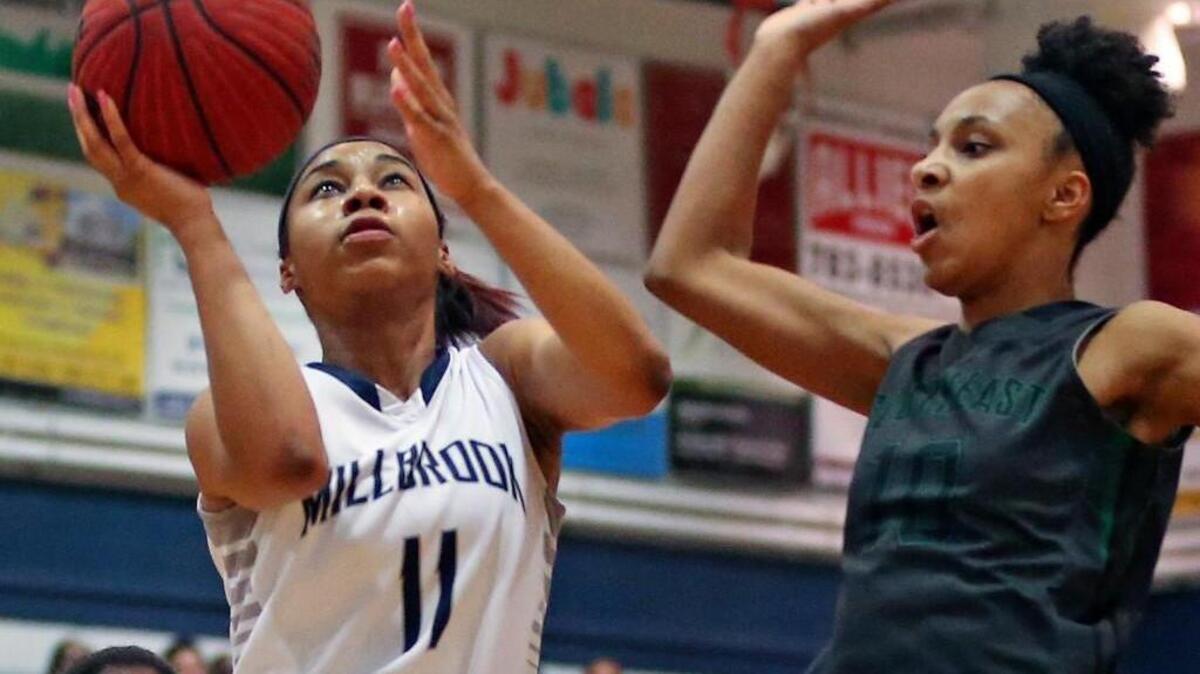 Millbrook's Dazia Powell (11) drives to the basket as Southeast Raleigh's Nevaeh Haddock (10) tries to stop the shot. Powell sunk crucial free throws with 4 seconds left in the game to secure the win for the Wildcats.