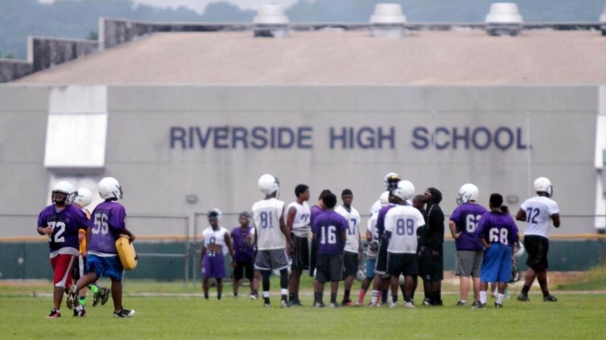 
Riverside High football players move from post to post on the practice field during the first day of high schools' football season practice at Riverside Friday, August 1, 2014.
