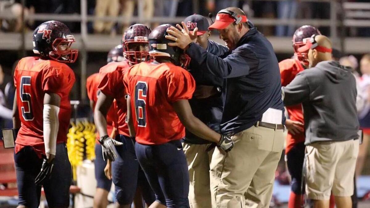 Southern Nash interim football coach Brian Batchelor hugs Kendrick Bell (6) as the Firebirds came off the field against Rocky Mount in Bailey, N.C. on Friday, October 28, 2016.