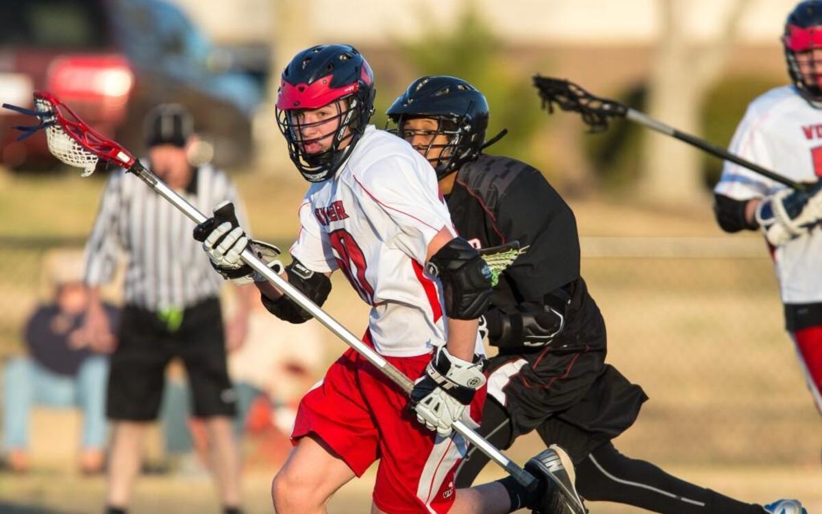 Voyager's Jay Brewer (20) runs with the ball ahead of a J.F. Webb defender during during a high school lacrosse game in Durham, N.C. on Wednesday, Mar. 22, 2017.
