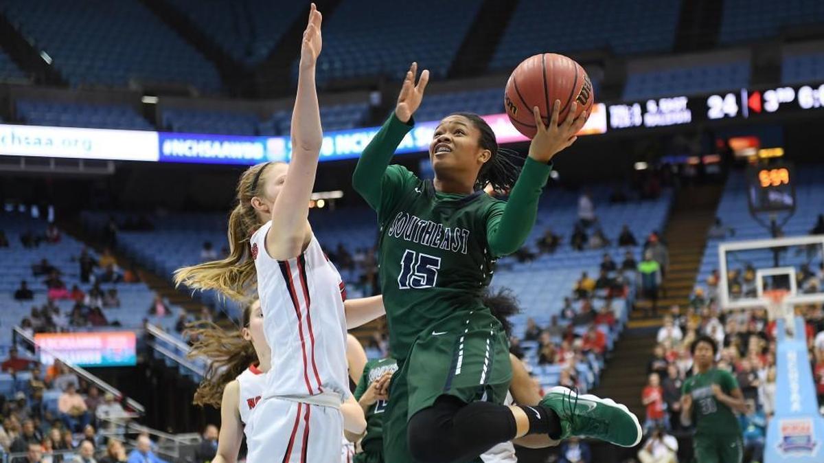 Jada McMillian (15) of Southeast Raleigh scores a two point basket against Lindsay Gauldin, left, of Northwest Guilford. The Southeast Bulldogs played the Northwest Guilford Vikings in a girls basketball game that counted for the NCHSAA 4A championship that took place at the UNC Dean Smith Center in Chapel Hill, N.C. on Saturday, March 10, 2018. Northwest Guilford won 44-36.