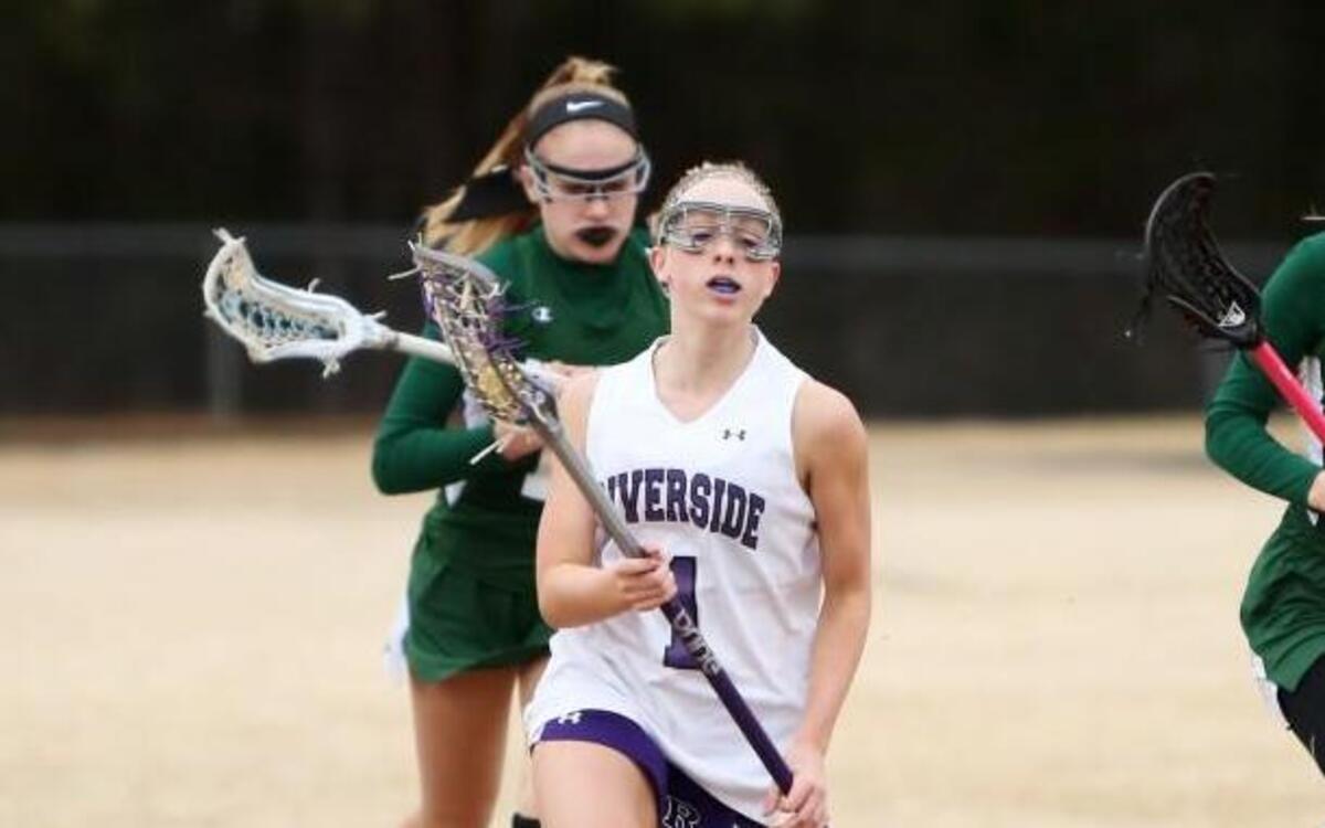 Riverside's Madison Nichting (1) outruns her defenders to bring the ball across the field during the Pinecrest Patriots' 13-3 win over the Riverside Pirates at Riverside High School in Durham, N.C., Friday, March 17, 2017.